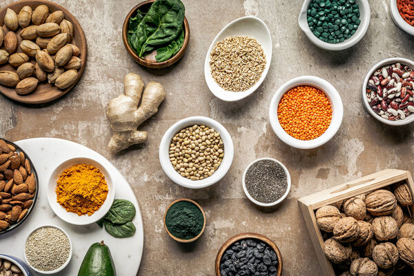 flat lay of superfoods, spices and legumes on textured rustic background