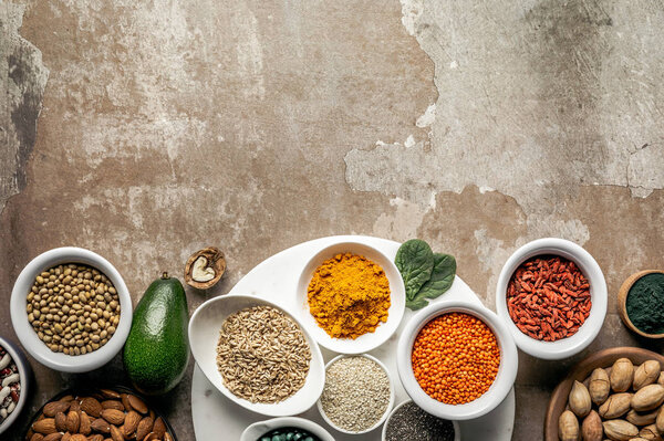 top view of superfoods and legumes on textured rustic background with copy space