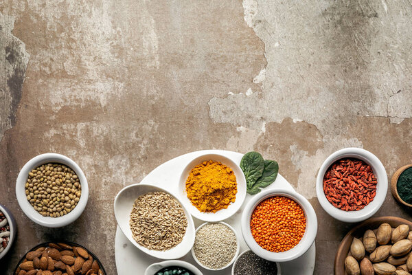 flat lay of superfoods and legumes on textured rustic background with copy space