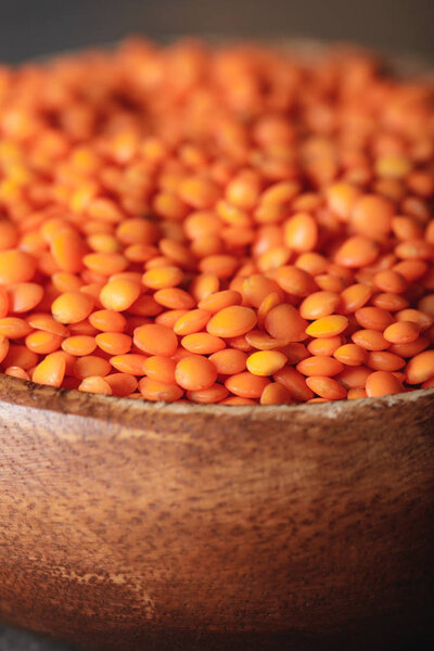 selective focus of red lentils in wooden bowl