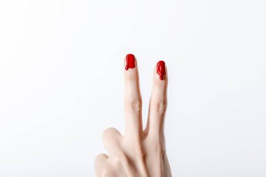 cropped view of woman showing peace sign with dripping red nail polish isolated on grey clipart