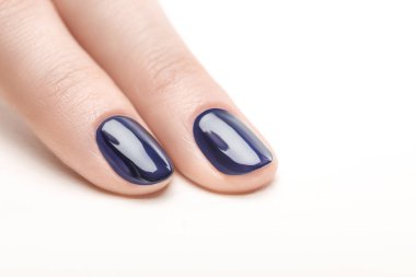 fingernails with shiny navy blue nail polish on white background clipart