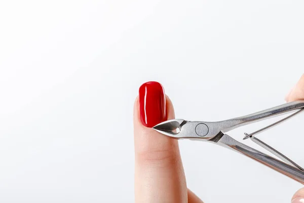 Manicure Usando Cutícula Nipper Unha Com Esmalte Vermelho Isolado Branco — Fotografia de Stock