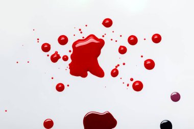 top view of abstract red spills with drops isolated on grey clipart