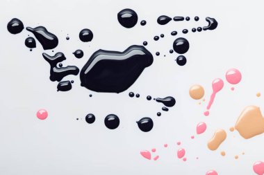top view of abstract black spills with pink and beige drops isolated on grey clipart