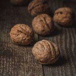 Close up view of walnuts on wooden backdrop