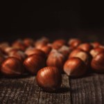 Close up view of hazelnuts on wooden surface on black background