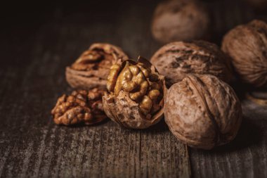 close up view of shelled and whole walnuts on wooden tabletop clipart