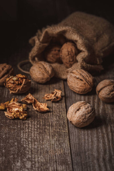 close up view of walnuts in sack on wooden background