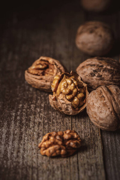 close up view of shelled and whole walnuts on wooden tabletop