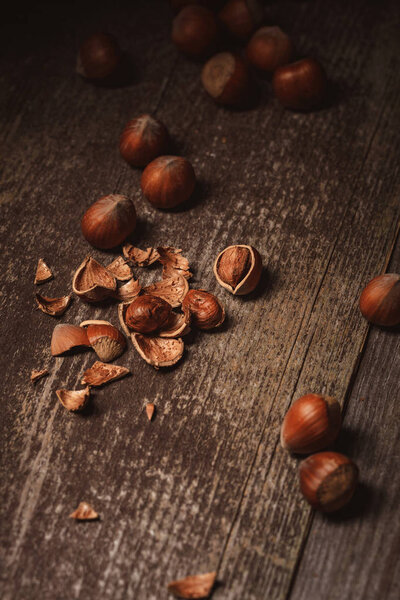 close up view of shelled hazelnuts and husk on wooden tabletop