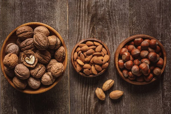 Bovenaanzicht Van Noten Kommen Gerangschikt Houten Tafelblad — Stockfoto