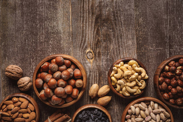 top view of nuts in bowls arranged on wooden tabletop
