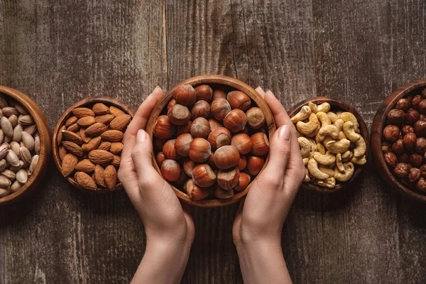 Partial View Woman Holding Bowl Hazelnuts Wooden Tabletop Different Nuts — Stock Photo, Image