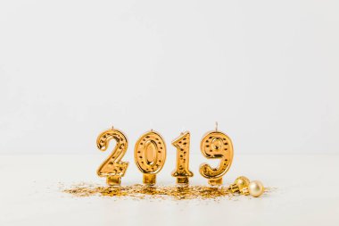 Altın 2019 mumlar, parlak Noel baubles ve beyaz zemin üzerine konfeti