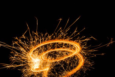 close-up view of festive burning new year sparkler on black background clipart