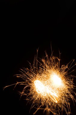 close-up view of bright burning new year sparkler on black background   clipart