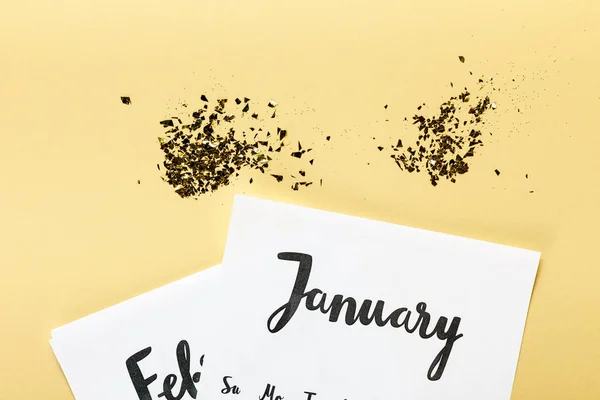 Gyllene Konfetti Med Januari Och Februari Kalender Beige Bakgrund — Gratis stockfoto