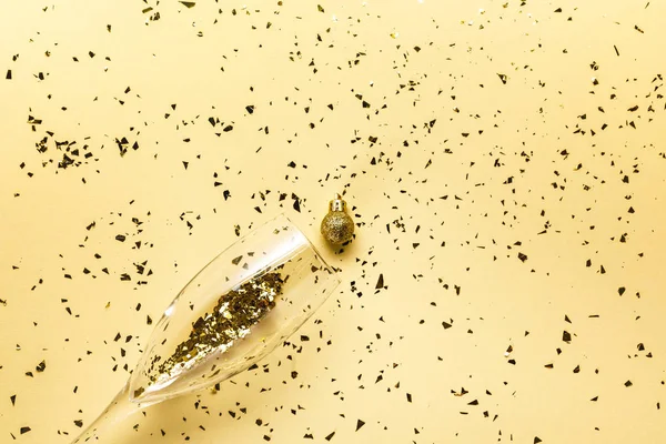 Golden Festive Confetti Champagne Glass Shiny Christmas Ball Beige Background — Stock Photo, Image