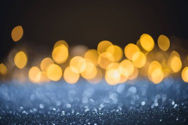 selective focus of blurred sparkling lights and bokeh on black clipart
