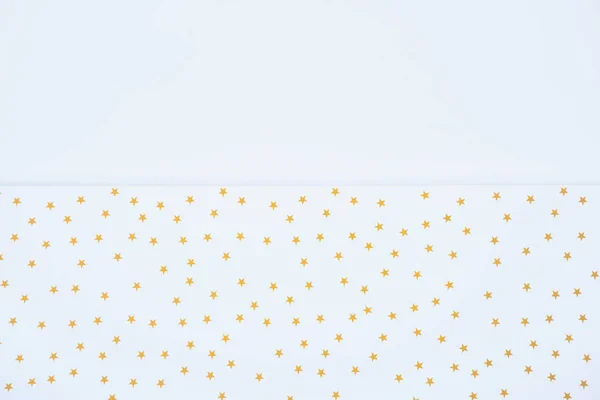 elevated view of festive paper decorated by golden stars isolated on white 