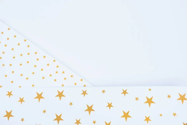 top view of festive paper decorated by golden stars isolated on white 