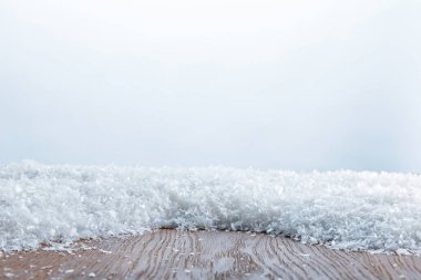 brown striped textured board covered with snow on white clipart