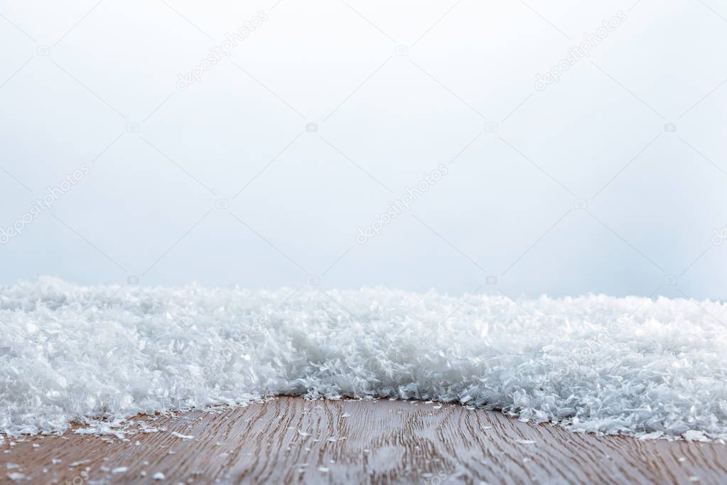 brown striped textured board covered with snow on white