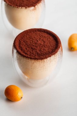 tiramisu tatlı ile kumquats gri masada bardaklarda kakao tozu