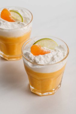 turuncu mousse bardaklarda mandalina ve limon dilimleri ile