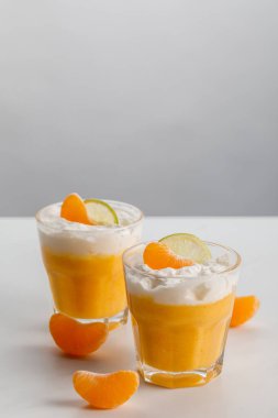 mandalina ve limon dilimleri ile turuncu mousse ile iki bardak