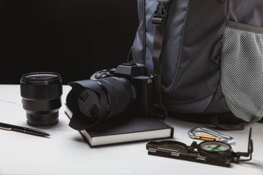 objektif, kalem, defter, pusula ve sırt çantası siyah ile fotoğraf makinesi görünümünü kapat