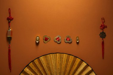 geleneksel altın Çin süslemeleri ve fan ile kahverengi zemin üzerinde hiyeroglifler  