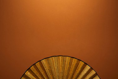 kahverengi zemin üzerinde hiyeroglifler ile geleneksel altın Çin fan üstten görünüm