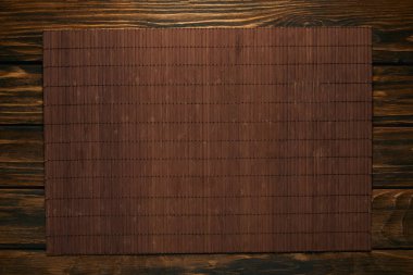 top view of empty brown bamboo mat on wooden table clipart