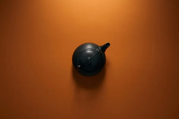 棕色背景上的黑色陶瓷茶壶的顶部视图 — 图库照片