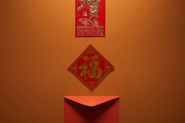 red envelope and hieroglyphs on brown background, chinese new year concept 