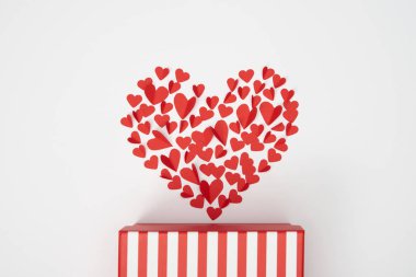 Yukarıdan küçük kırmızı kağıt kalp şeklinde düzenlemenin kalpler kesip çizgili hediye kutusu beyaz arka plan üzerinde