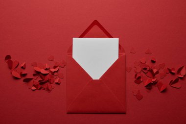 top view of blank white letter in envelope with paper cut hearts on red background clipart