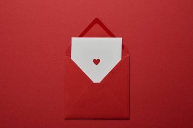 top view of white letter with heart in envelope on red background clipart