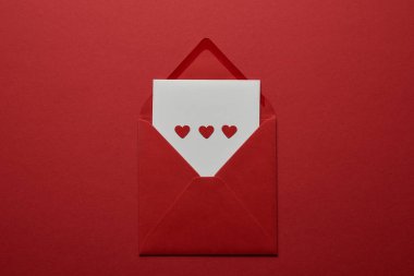 top view of white letter with hearts in envelope on red background clipart