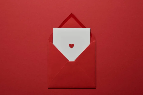 Kırmızı Zemin Üzerine Beyaz Mektup Zarfı Kalp Ile Üstten Görünüm — Stok fotoğraf