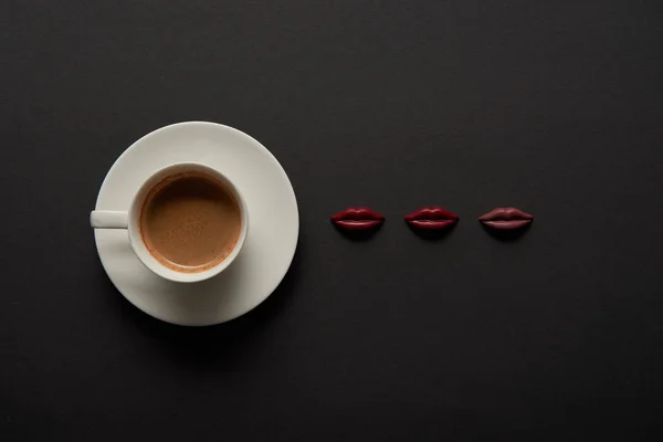 在黑色背景的巧克力嘴唇附近的咖啡的顶部看法 — 图库照片
