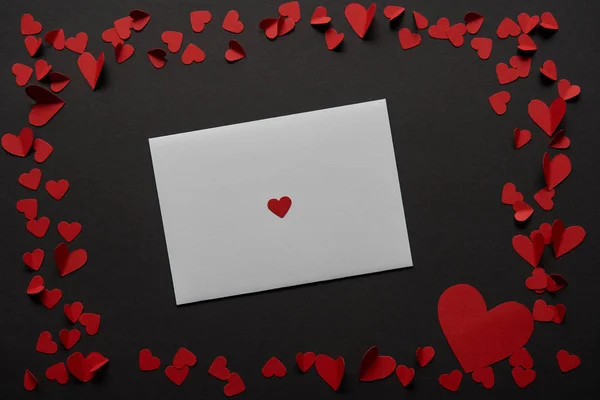 Top view of white greeting card with frame made of red paper cut hearts on black background — Stock Image Top View White Greeting Card Frame Made Red Paper Cut Stock Image