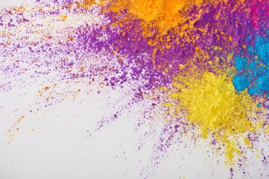 top view of explosion of yellow, purple, orange and blue holi powder on white background clipart