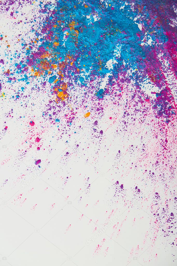 top view of explosion of purple and blue holi powder on white background