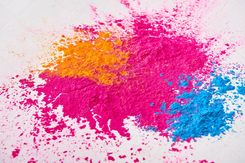 top view of explosion of multicolored holi powder on white background