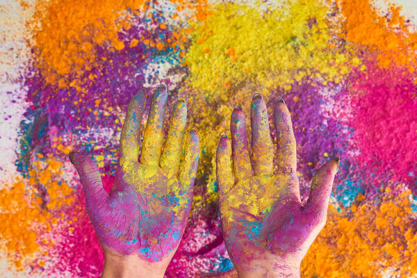 cropped view of woman with hands in multicolored holi powder