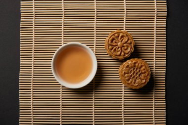 bambu masa mat üzerinde Çin mooncakes ve çay Kupası üstten görünüm