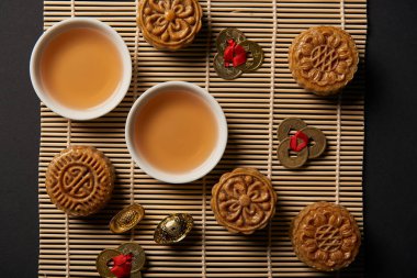 bambu masa mat üzerinde mooncakes, feng shui sikke ve çaydanlık bardak ile üstten görünüm